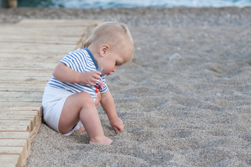 little child is playing with a shovel in the sand on the beach