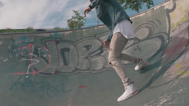 Skater guy sliding down a half pipe 