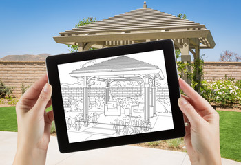 Female Hands Holding Computer Tablet with Drawing of Pergola on Screen, Photo Behind. © Andy Dean