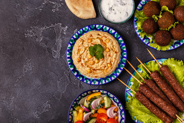 Classic kebabs, falafel and hummus on the plates.