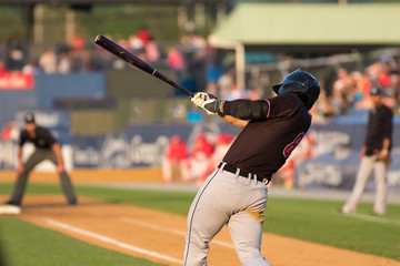 baseball player swinging at a pitch - obrazy, fototapety, plakaty