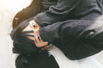Young pretty girl wearing black cotton sweatshirt on bedroom white tone