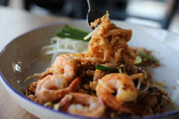 Pad thai with shrimp . Thai food on wood background
