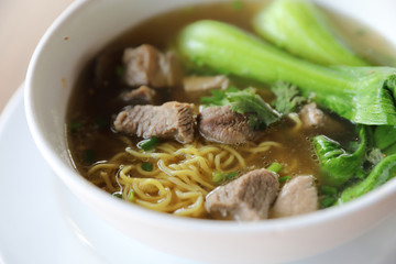 Chinese noodles with pork on wood background