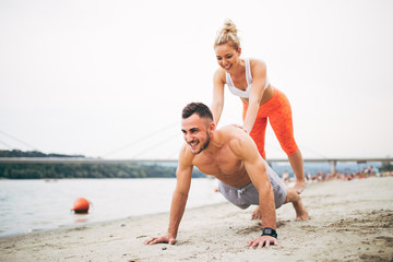 Group young attractive people having fun on beach and doing some fitness workout.