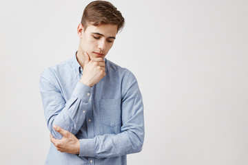 Picture of serious young man standing by the wall. Maybe he will went abroad. Or not. Maybe he will...