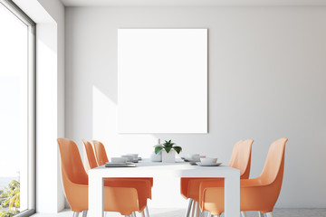 White dining room, orange chairs, poster close up