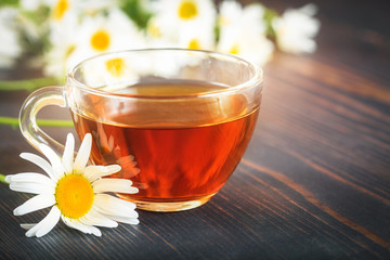Chamomile tea in a transparent cup. The concept of herbal medicine.