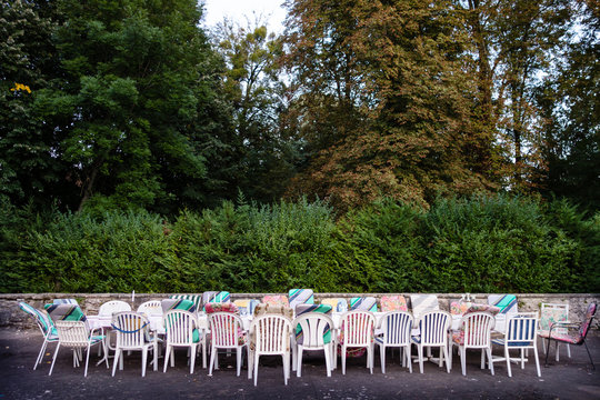 Long Table And Chairs With Mixed Upholstery Outside On The Courtyard Waiting For A Group Of Friends On Holidays To Populate Them. Concept For Team Building, Friendship Or Togetherness.