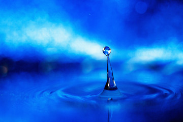 a drop of water on a blue background in smoky light