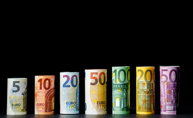 Several hundred euro banknotes stacked by value.Rolls Euro bankn