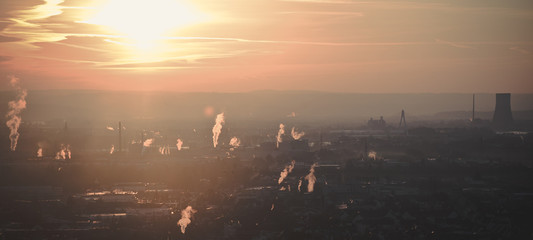 A city on the Rhine River at sunrise. smoke rising from the chimneys.