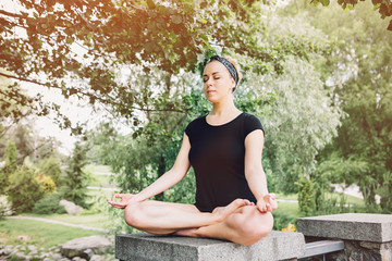 Young yoga woman practitioners yoga on nature.