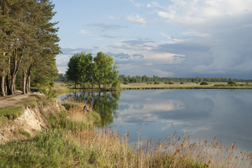 Man fishing at a flat rock coast at blue sky and blue water