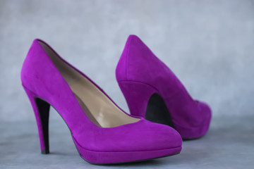 Fuchsia velvet  shoes heels on gray background.