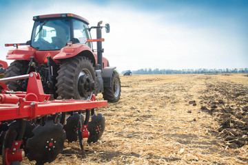 Red tractor in the field on a bright sunny day.
