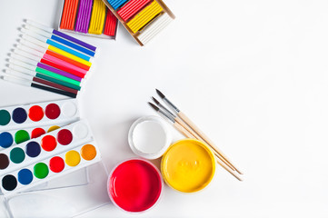 paints for drawing and tools, materials for creativity. White background, top view.
