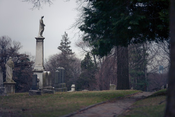 Obraz premium Cemetery monument by the path, cloudy weather