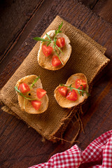 Three Bruschette with Tomato and Rocket Salad on Jute Napkin