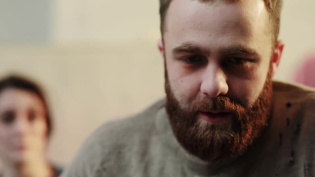 Close up face drunk man feel unhealthy in backgroung woman quarrel stress depressed home desperate kitchen drinker alcohol alcoholic guy beverage tired party woman male bottle slow motion portrait