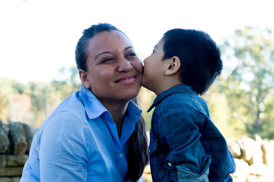 Latino boy giving his mother a kiss
