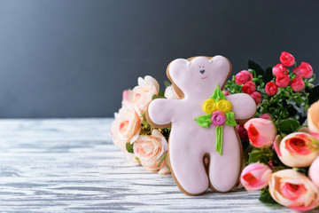 delicious gingerbread cookie teddy bear with flowers on a wooden background