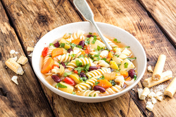 Minestrone soup. Vegetable soup with fresh tomato, celery, carrot, zucchini, onion, pepper, beans and pasta. Italian cuisine dish