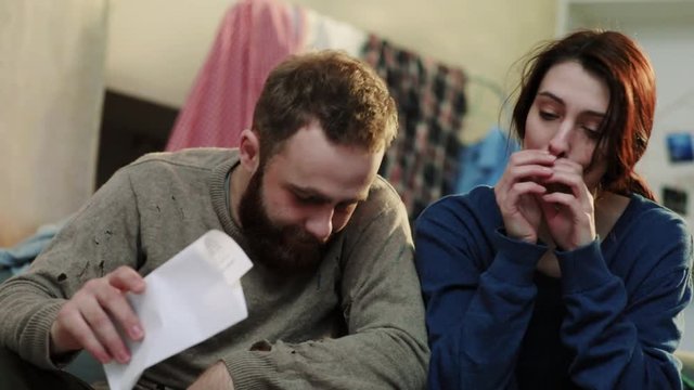 Portrait depression young woman and man sit on sofa feel sad stress fear alcoholic home desperate alcohol guy tired party woman male bottle slow motion close up frustrated