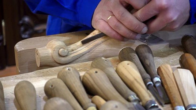 4K view of wood carving. The master is working on the pattern.