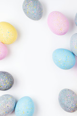 Stylish Frame of pale pink, blue and gray Easter eggs with copy space for text. Flat lay