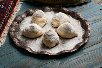 Badambura powdered pastry on Novruz tray. Azerbaijan traditional pastry cookie badambura on rustic table background