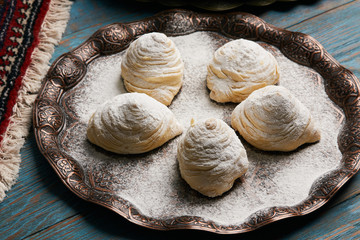 Badambura powdered pastry on Novruz tray. Azerbaijan traditional pastry cookie badambura on rustic table background