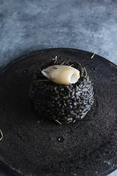 Black rice with cuttlefish, on black cement dish