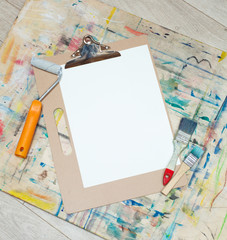 blank canvas mockup with paints and brushes on wooden table
