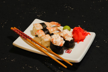 Nigiri Sushi set on white plate on black background. Japanese food. Asian tasty dinner.