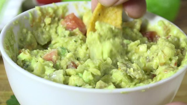 Scooping guacamole with a corn chip