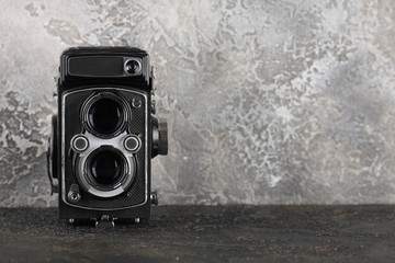 The old medium format film TLR camera on cement background.