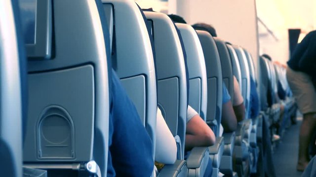 Airplane cabin interior with a lot of passenger on the chairs. Aircraft interior with people on the seats 