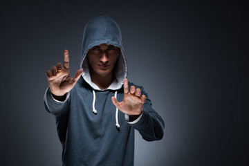 Young man wearing hoodie pressing virtual buttons