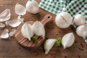 Composition with fresh cut onion and spices on wooden table