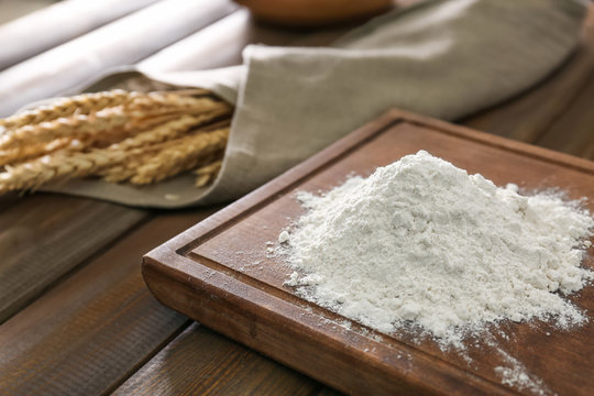 Wheat flour on wooden board, closeup