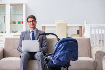 Businessman looking after newborn baby at home and teleworking