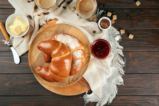 Composition with fresh tasty crescent rolls on wooden background