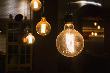 Old dusty round orange light bulb vintage style hang in darkness