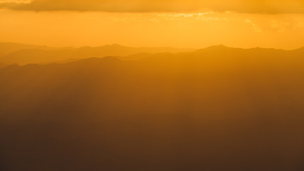 Golden sky with sunlight and the Mountains in sunset.