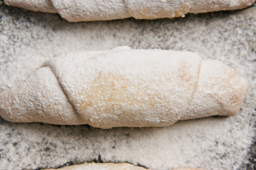 Mutaki cookies rolled with powdered sugar on copper tray on rustic wooden table, turkish food 