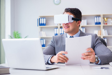 Businessman with virtual reality glasses in modern technology co