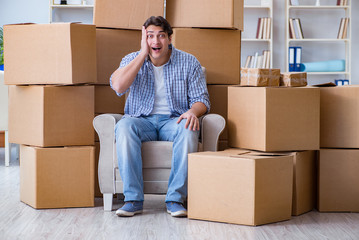 Young man moving in to new house with boxes