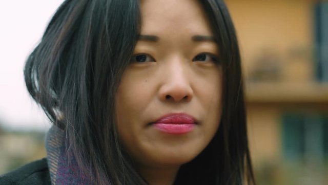 close up on attractive young chinese woman looking in camera- outdoor