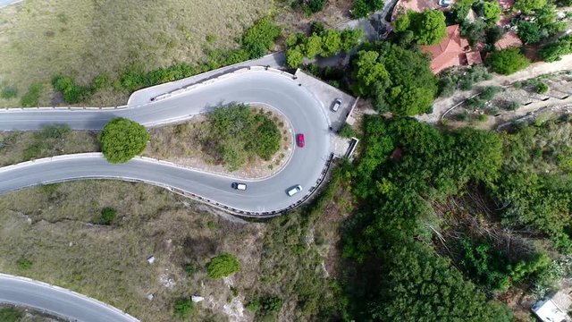 Aerial top down view of hairpin turn also called hairpin bend hairpin corner named for its resemblance to a hairpin bobby pin is bend in a road with a very acute inner angle vehicles driving over road
